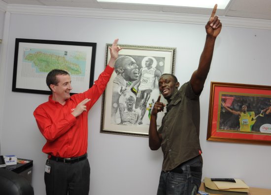 Digicel Jamaica CEO, Mark Linehan, and Usain Bolt strike what has become Usain's trademark pose -  Negril Travel Guide - Negril, Jamaica WI - NegrilTravelGuide.com - http://www.negriltravelguide.com - info@negriltravelguide.com